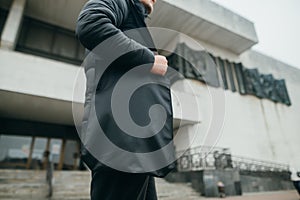 A man with a black eco bag in his hands walks around the city in cool weather