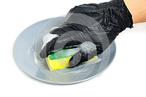 Man in black gloves washes a plate with a foam sponge on a white background