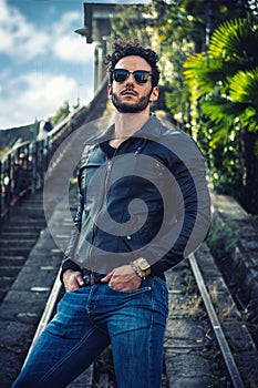 Man in black jacket and sunglasses posing for a picture