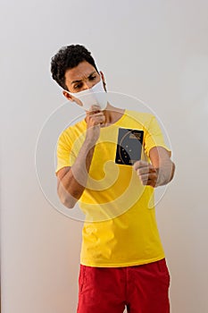 Man black with pandemic mask  holding a Brazilian passport Mercosur photo