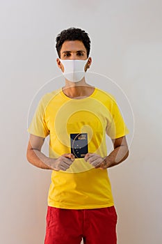 Man black with pandemic mask  holding a Brazilian passport Mercosur photo