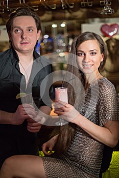 A man in a black shirt and a girl in a chaindress