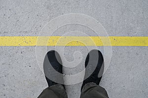 A man with black shoe and yellow line