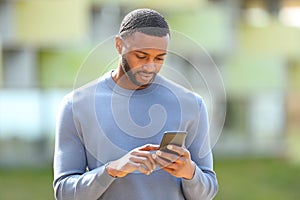 Man with black skin checking cell phone in the street