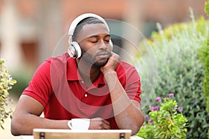 Man with black skin listening to music in a bar