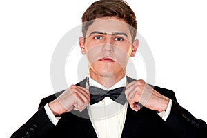 Man in a black suit adjusts his bow tie close-up
