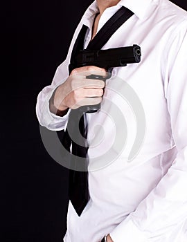 Man in black suit holding gun in hand. Secret agent, mafia, bodyguard concept