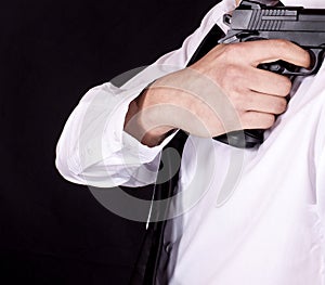 Man in black suit holding gun in hand. Secret agent, mafia, bodyguard concept