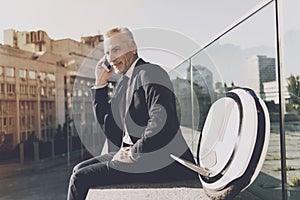 Man in a black suit talking on the phone.