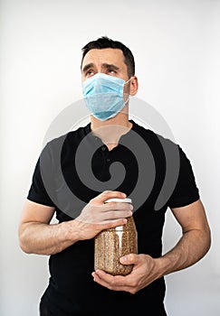 man in a black t-shirt with a medical mask and buckwheat on an  white background
