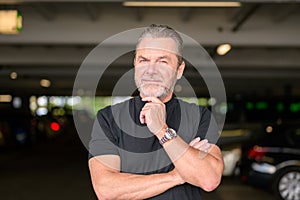 Man with a black T-shirt wears a stylish watch and looking to camera