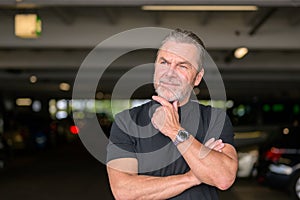 Man with a black T-shirt wears a stylish watch and looking to side