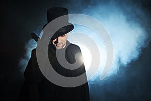 Man in a black top hat and cloak. Demonic image. Magician illusionist