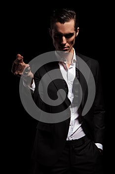 Man in black tuxedo with hand in pocket snapping fingers