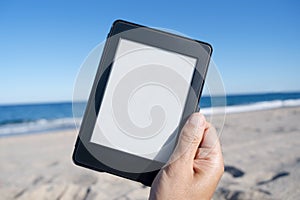 Man with a blank tablet or e-reader on the beach
