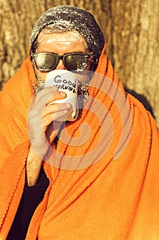 Man in blanket with cup