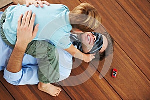 Man, blindfold and playing with child in living room, happy and family home with support of businessman with kid. Man