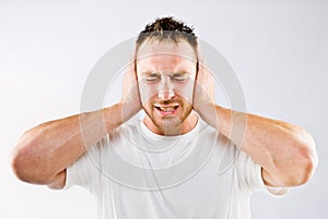 Man blocking out loud noise from ears photo