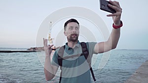 Man blogger records video blog on mobile phone for social media about accident of wreck tanker Delfi with oil in Odessa