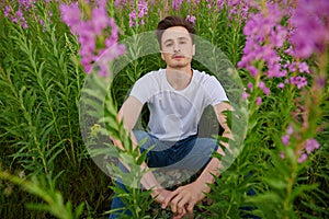 Man in a blooming ivan tea photo