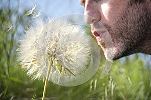 Man blowing a dandelion