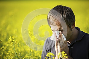 Man blowing his nose in canola field