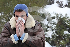 Man blowing his nose in the cold weather
