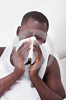 Man blowing his nose in a handkerchief