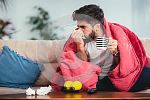 Man blowing his nose while lying sick