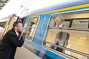 Man blowing kiss to woman on train