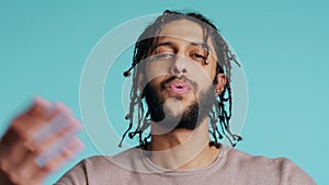 Man blowing kisses to camera, being flirty, studio background