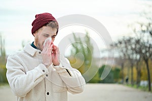 Man blowing nose into tissue during winter, flu.