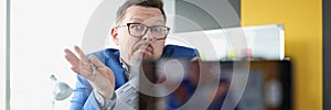 A man in a blue jacket looks at the camera in confusion photo