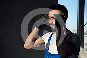 Man in blue overalls putting on safety glasses