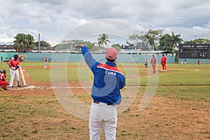 a man in blue and red jersey and baseball uniform pointing out at a pitch