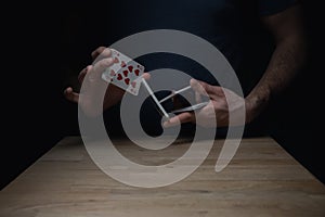 Man Shuffling Deck of Red Cards at Wooden Table Card Tricks