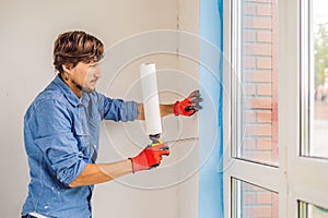 Man in a blue shirt does window installation