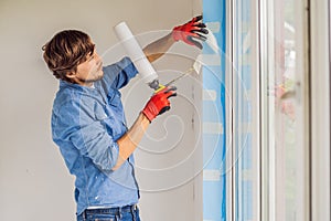 Man in a blue shirt does window installation