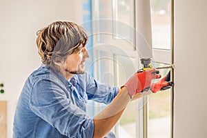 Man in a blue shirt does window installation