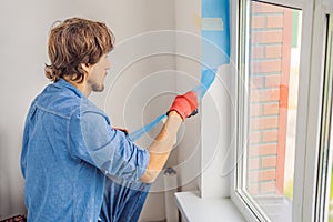 Man in a blue shirt does window installation