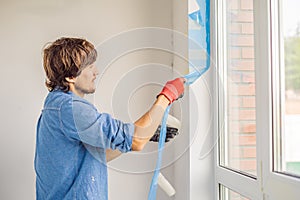 Man in a blue shirt does window installation