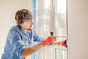 Man in a blue shirt does window installation