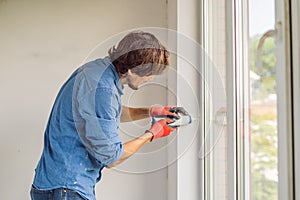 Man in a blue shirt does window installation