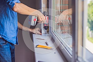 Man in a blue shirt does window installation