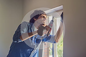 Man in a blue shirt does window installation