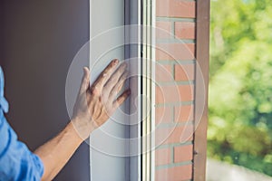 Man in a blue shirt does window installation