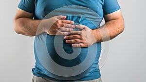 Man in Blue Shirt Holding Stomach, Concept of Digestive Issues or Hunger. Simple Style and Casual Clothing. Stock