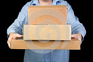 Man in blue shirt holds three cardboard boxes