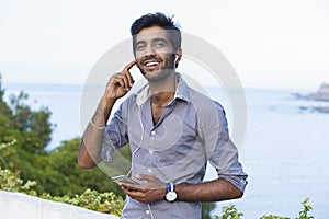 Man in blue shirt looking upwards in thought listening to music