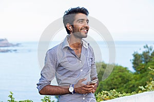 Man in blue shirt looking upwards in thought listening to music